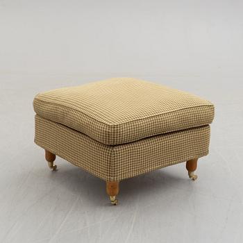 A foot stool by Fogia dressed in Ralph Lauren fabric.