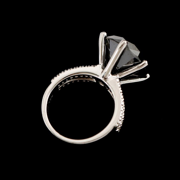 RING, 18 k vitguld, svart briljantslipad diamant 11.74 ct, samt 36 mindre briljanter tot ca 0.32ct.