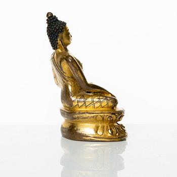 A gilt copper-alloy figure of Aksobhya Buddha, 14th/15th century, Tibet or Nepal.