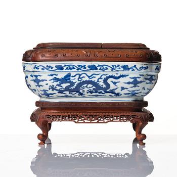 A blue and white quatrefoil dragon box with wooden cover and stand, Ming dynasty, Wanli mark and period (1573-1620).