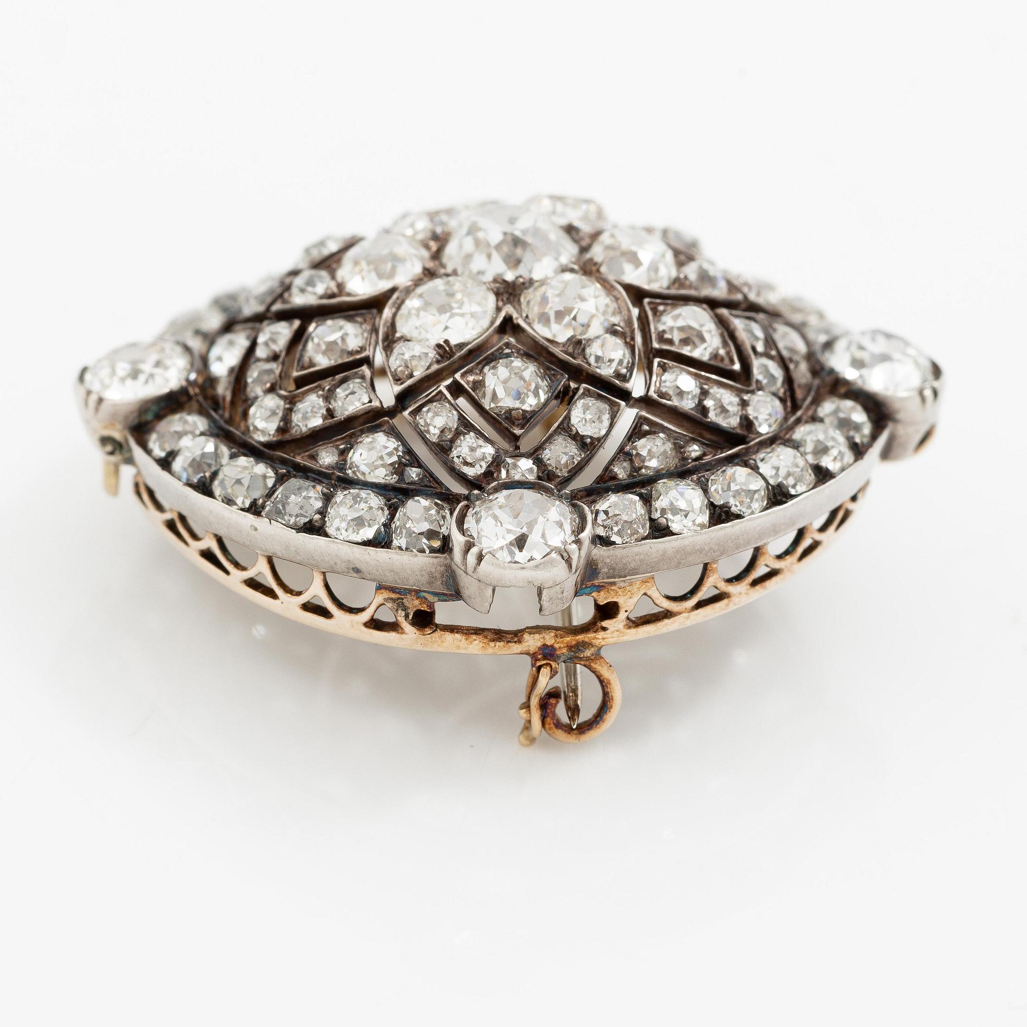 A brooch/pendant in gold and platinum with old-cut diamonds.
