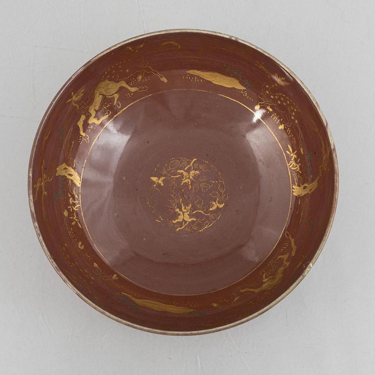 A brown glazed bowl with gilded decoration of animals and antiques, Qing dynasty, 19th century.