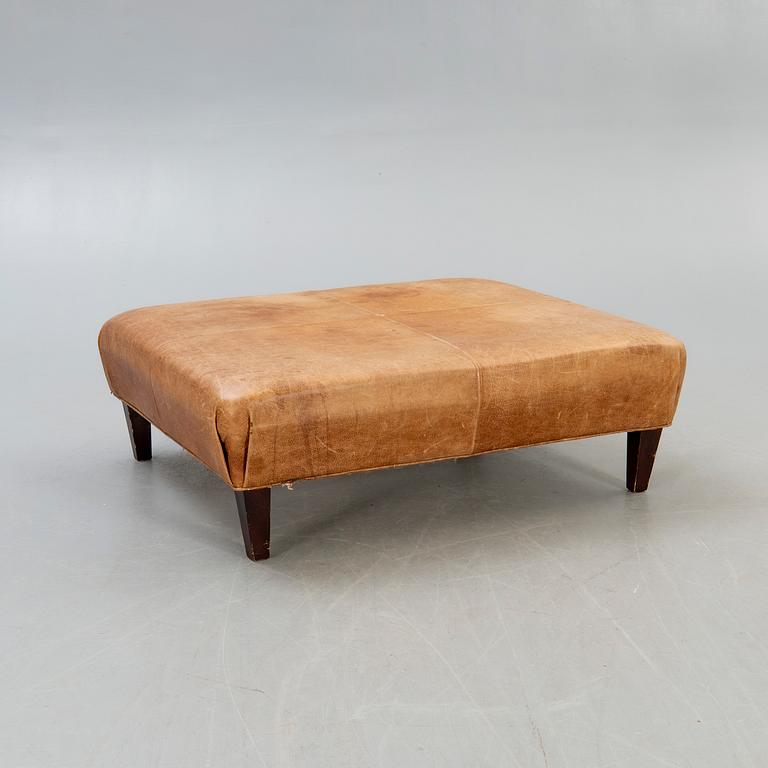 A leather ottoman/coffee table alter part of the 20th century.
