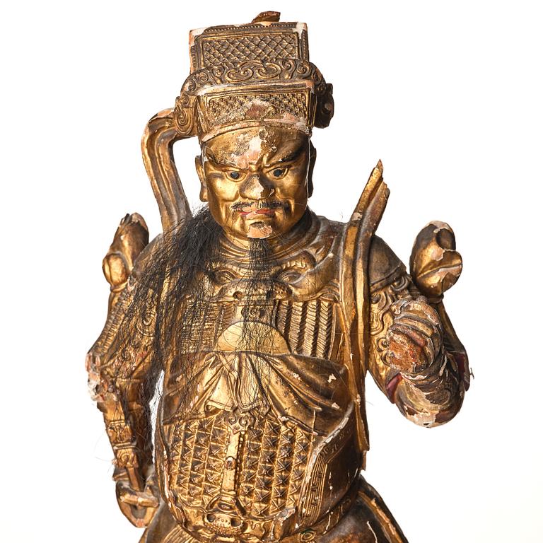 A gilt and lacquered standing figure of a guardsman, Qing dynasty.