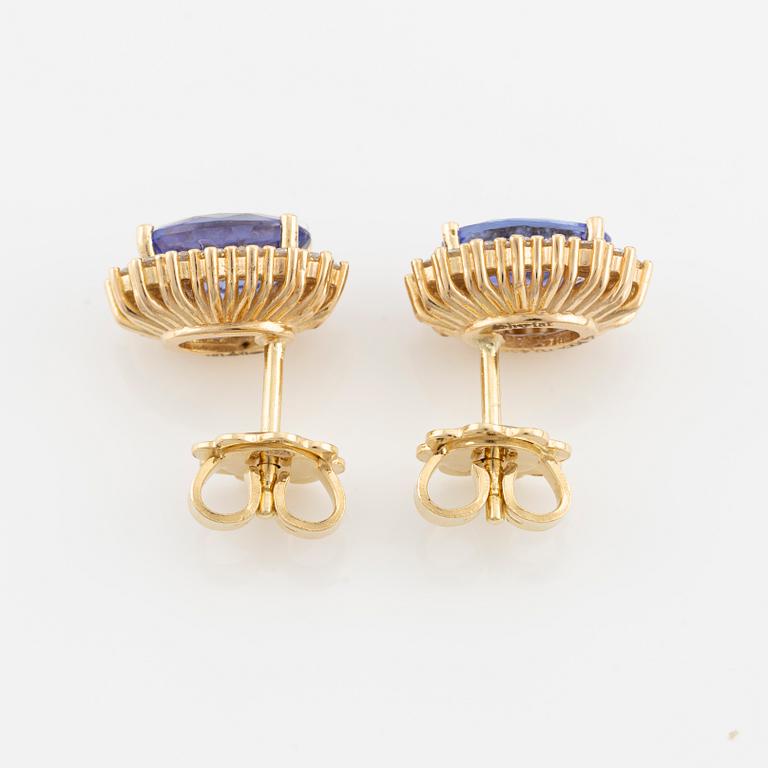 A pair of 18K gold earrings with faceted tanzanites and round brilliant-cut diamonds.
