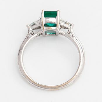 An 18K white gold ring, set with a Zambian emerald and trillion-cut diamonds.