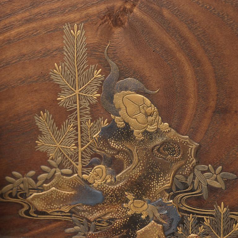 A Japanese wooden and lacquered table screen on a blue and white Ming dynasty porcelain base.