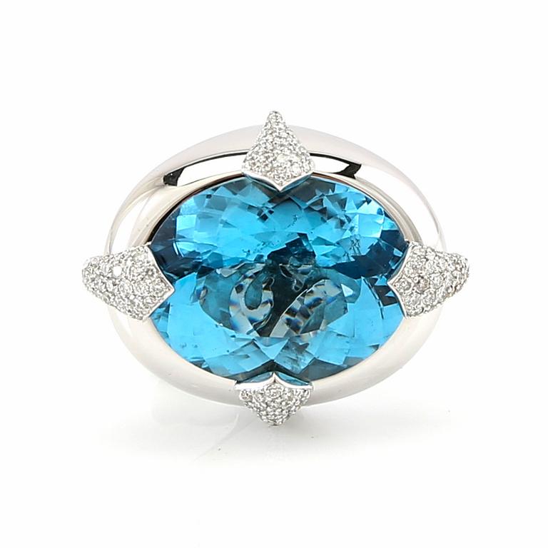 Pavé-set ring/cocktail ring in 18K white gold with an oval faceted blue topaz and round brilliant-cut diamonds.