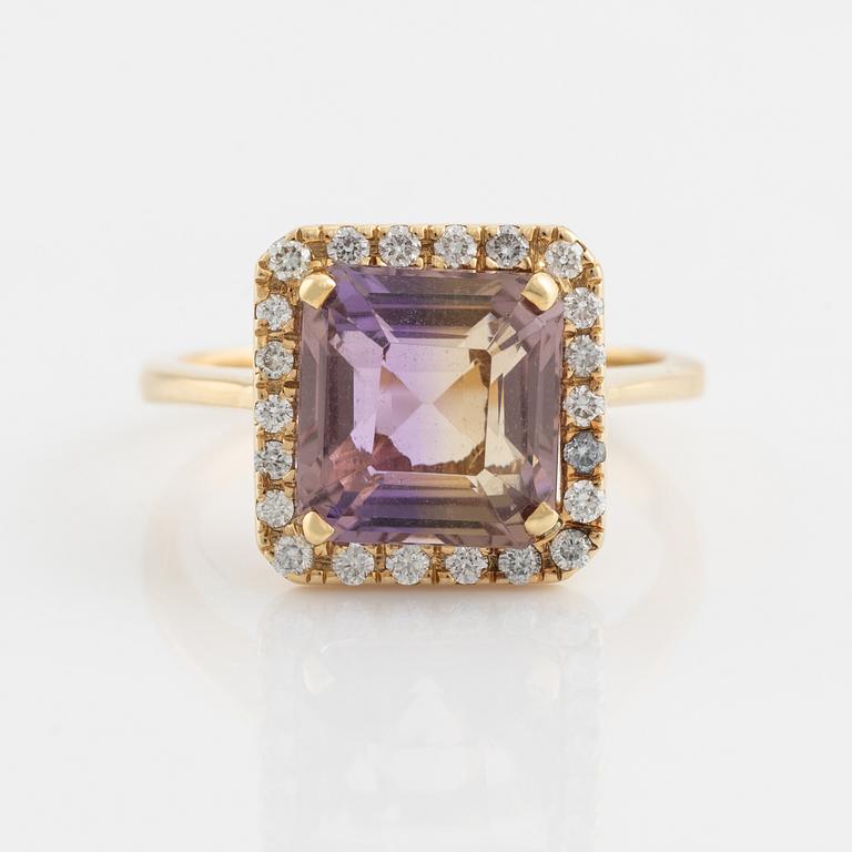 An 18K gold and ametrine ring set with round brilliant-cut diamonds.