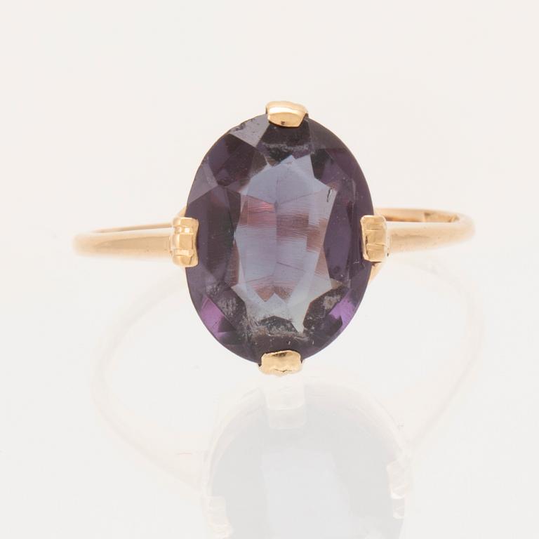 An 18K gold ring set with a synthetic colourchange purple sapphire.