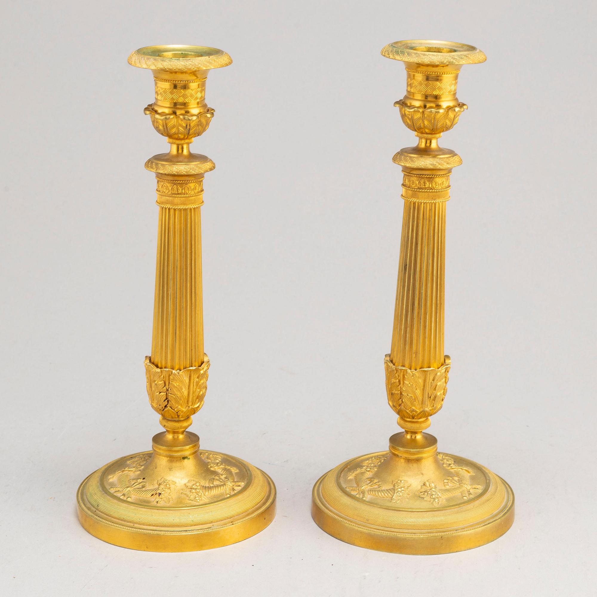 A pair of first half of the 19th century Empire candel sticks, gilded bronze, first half of the 19th century.