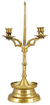 1031. A two-light brass candelabra, probably late Gothic.