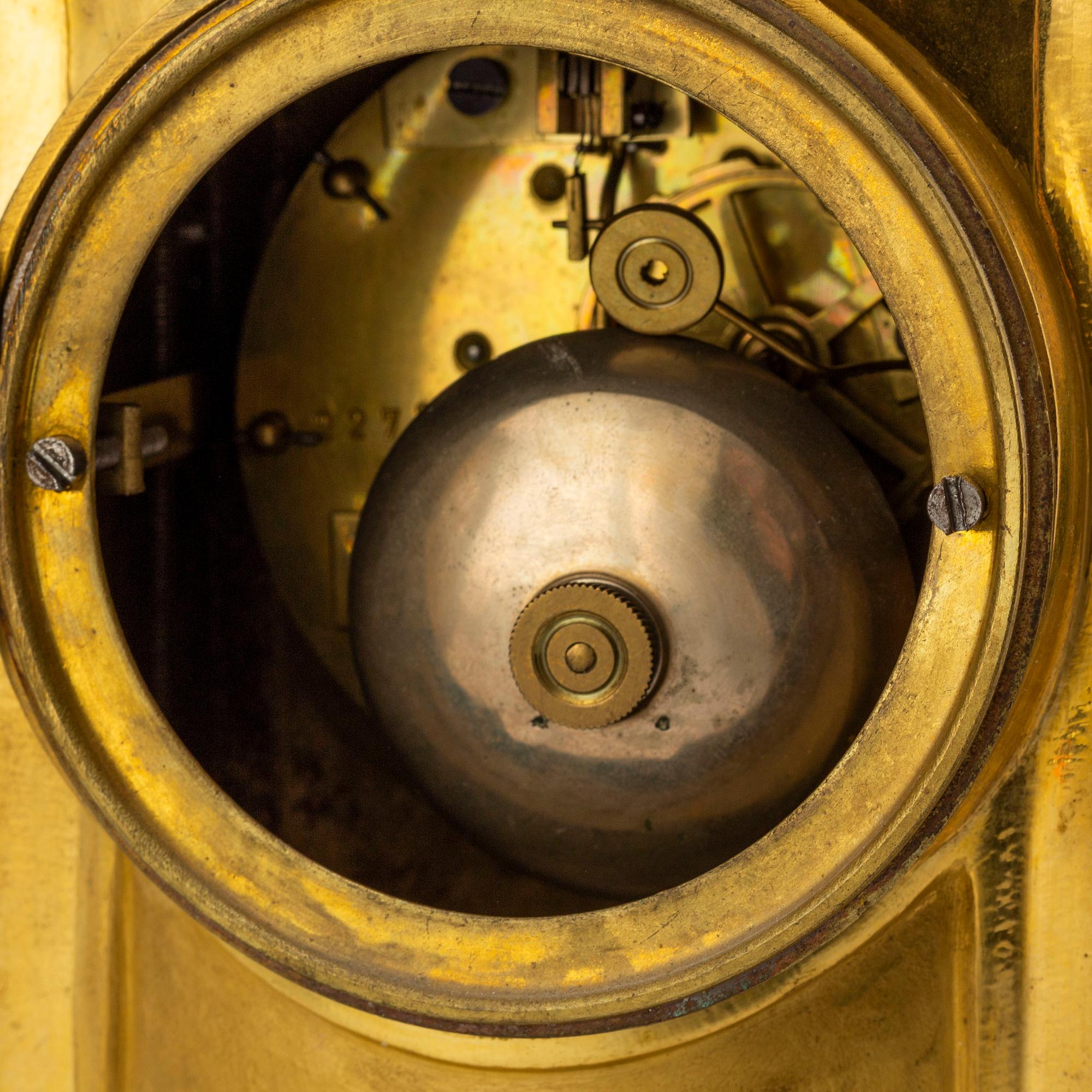 A late 19th century pendulum clock and a pair of candelabras.