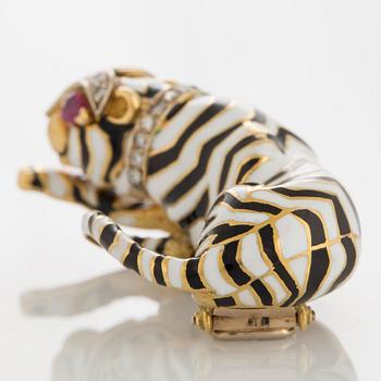 A cat brooch in 18K gold decorated with black and white enamel and set with round brilliant-cut diamonds.