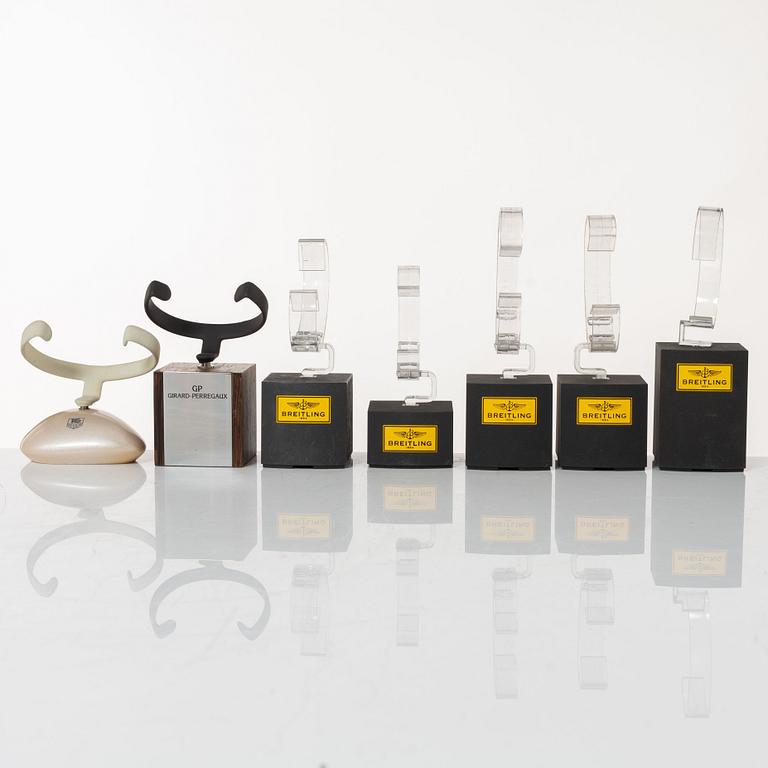 Clock stands, 7 pcs, Breitling, TAG Heuer and Girard-Perregaux.