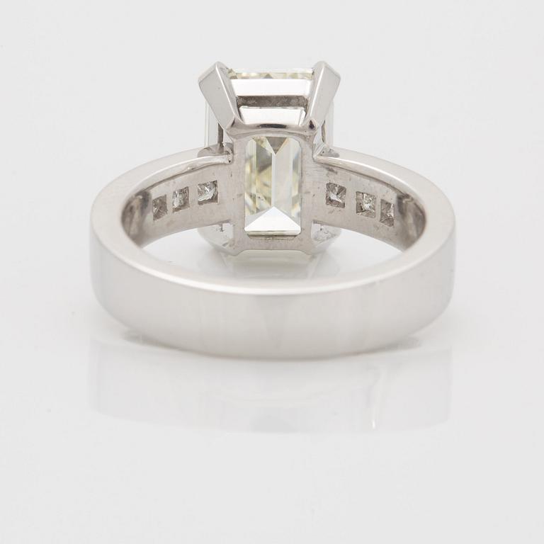 A RING set with an emerald-cut diamond.