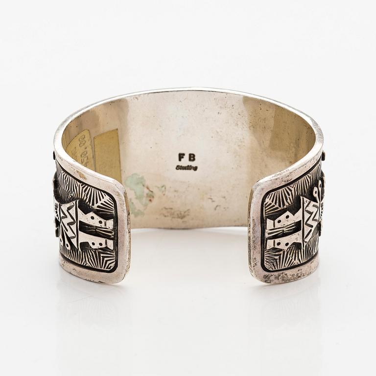 A silver bracelet with coral.