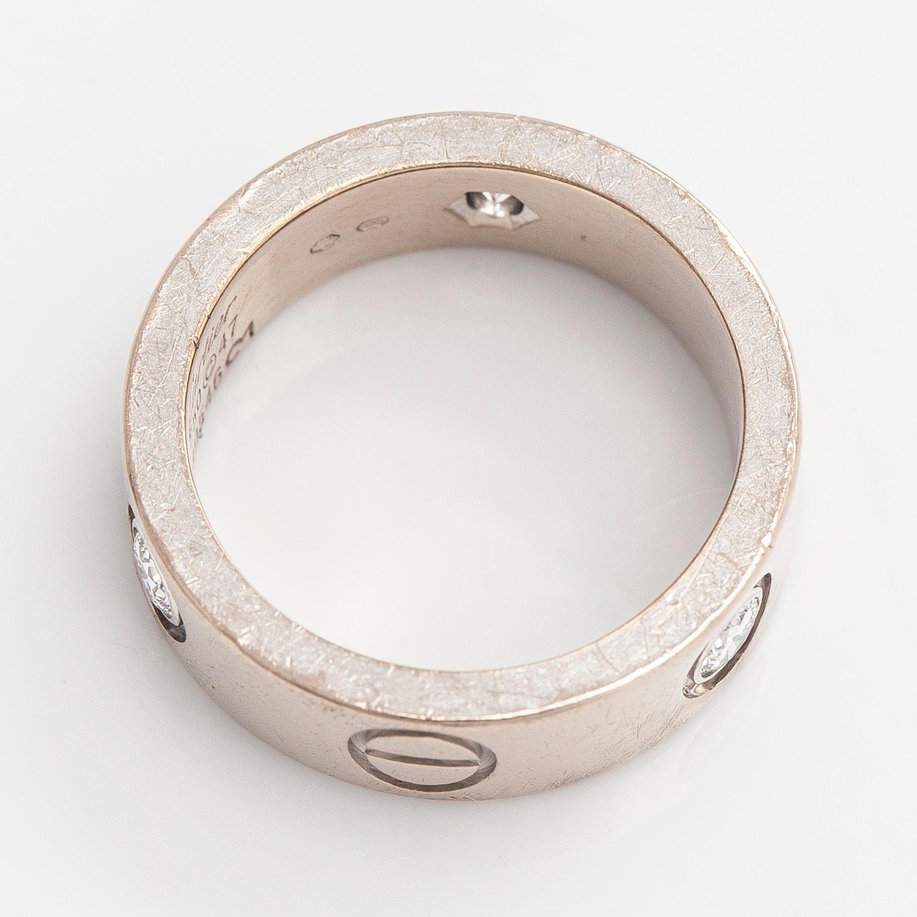 Cartier, an 18K white gold 'Love' ring with three brilliant-cut diamonds.