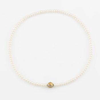 Ole Lynggaard clasp in 18K gold with a round brilliant-cut diamond and a freshwater cultured pearl necklace.