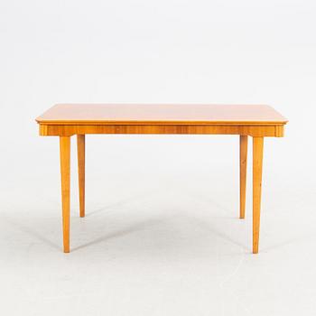 A 1940s mahogany and walnut dining table.